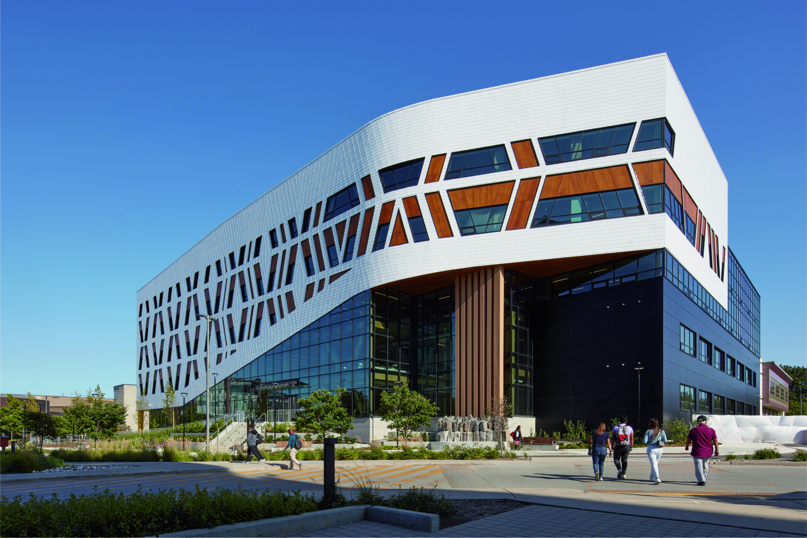 Exterior view of the Centennial College with four users approaching the building entrance